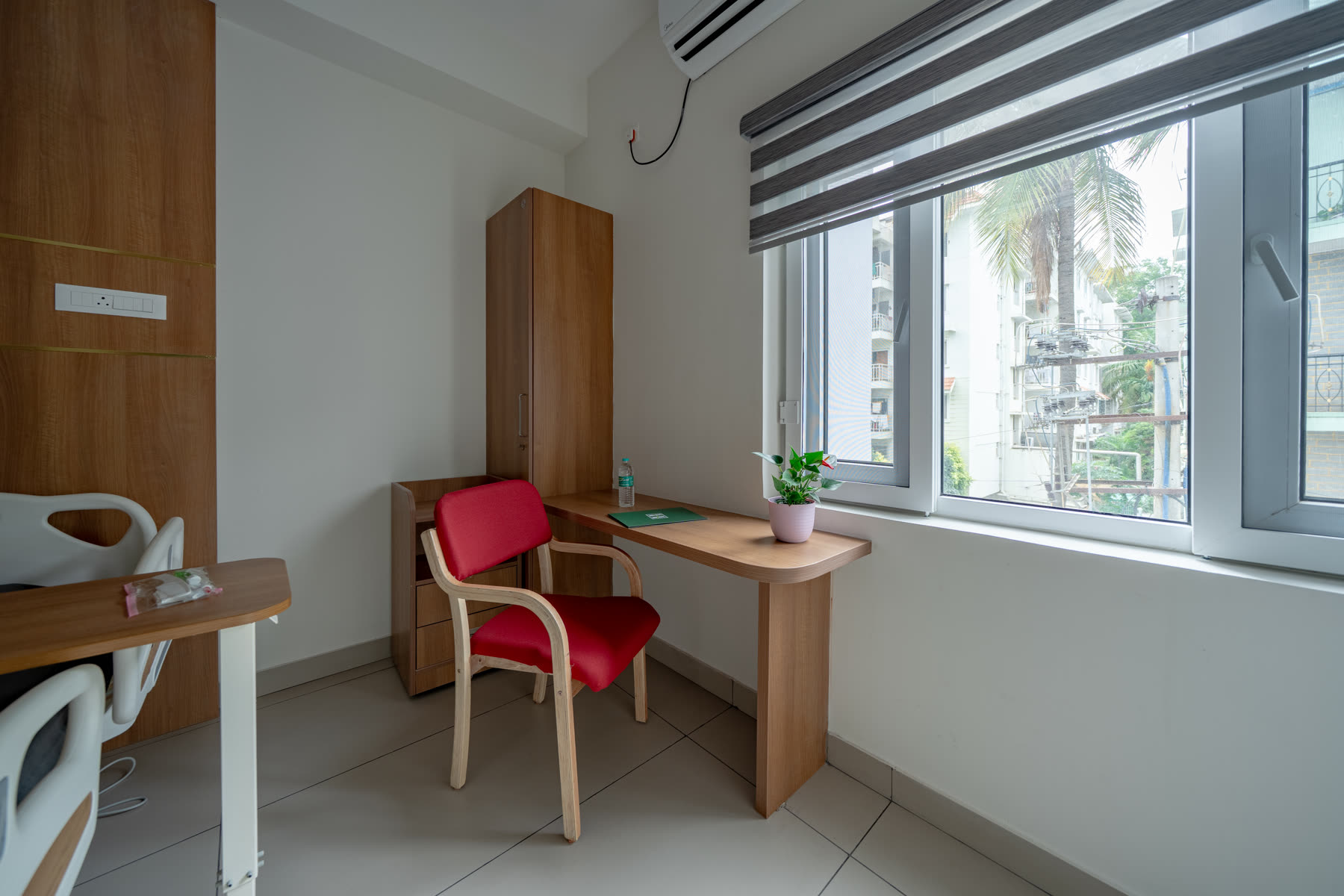 Patient room with writing desk, natural light and comfortable seating