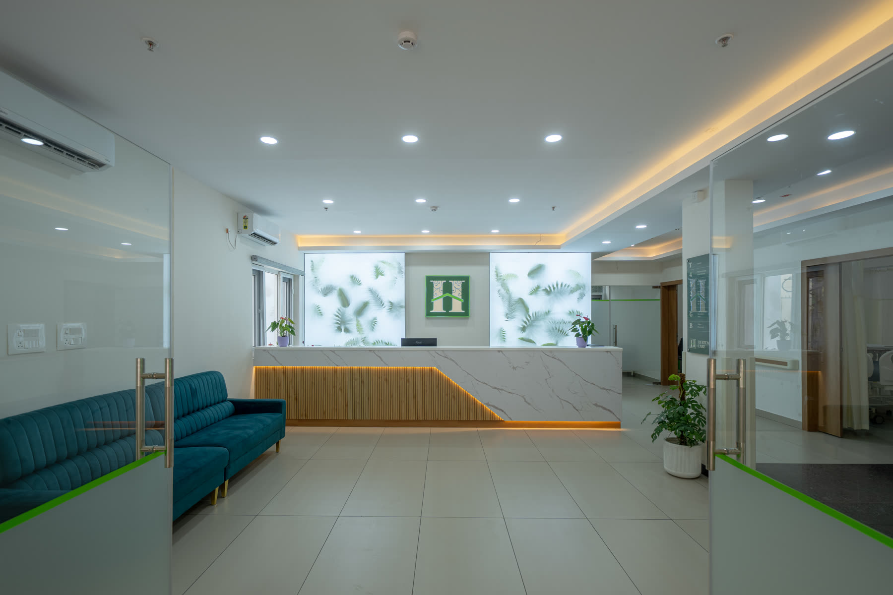 Modern healthcare reception with marble front desk, blue seating and soft ambient lighting